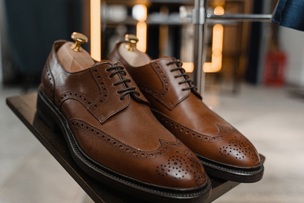 home-img Classic brown leather brogue shoes with detailed perforations on a stylish display.
